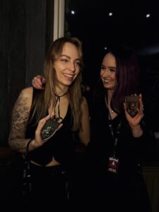 Twee award-winnende tattoo artists van Ink United tijdens de Tattoo Conventie in Namen, trots poserend met hun prijzen voor blackwork en neotraditional tattoos.
